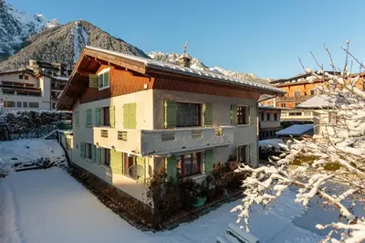a house with two cars parked in a parking lot at Edelweiss 2 Apartment and Studio - Chamonix All Year in Chamonix-Mont-Blanc