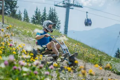 a person riding a bike down a hill with flowers at ELI422 Appartement standing 6 pers centre village in Les Carroz d'Araches