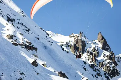 a person flying a parachute over a snowy mountain at Chalet Martinique - Chamonix All Year in Chamonix-Mont-Blanc