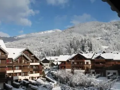 a ski resort with snow covered buildings and a mountain at Studio confortable pour 4 personnes à Samoëns - FR-1-846-17 in Samoëns