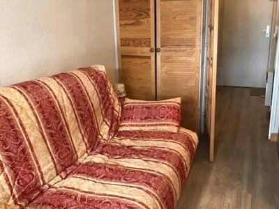 a living room with a couch with a blanket at Studio cosy à Samoëns pour 4 personnes - FR-1-846-21 in Samoëns