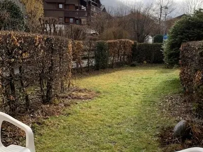a garden with a fence and a chair in the grass at Studio cosy à Samoëns pour 4 personnes - FR-1-846-21 in Samoëns