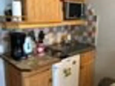 a kitchen with wooden cabinets and a counter top at Studio cosy à Samoëns pour 4 personnes - FR-1-846-21 in Samoëns
