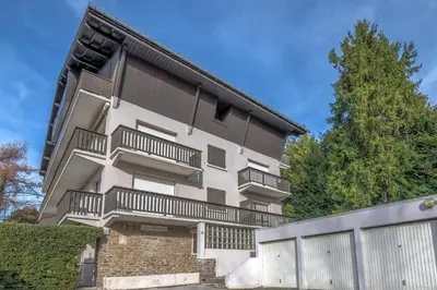 an apartment building with balconies and a fence at Appartement Perret - Welkeys in Megève