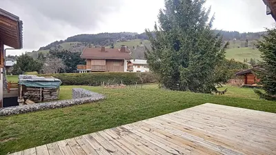a backyard with a wooden deck and a house at Chalet des Pres- 3 chambres - JAILLET - in Demi-Quartier