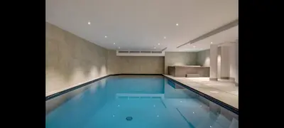 a swimming pool with blue water in a building at Les Ecrins de Kayla -Piscine - Sauna in Les Houches