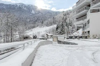 a snow covered street in front of a building at Le Manoir de Kayla - Piscine, Sauna & Vue in Les Houches