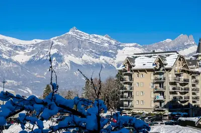 a building with a snow covered mountain in the background at Grand Panorama in Saint-Gervais-les-Bains