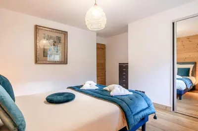 a bedroom with a bed with a blue blanket at Bright apartment ideal in Les Houches for 4 in Les Houches