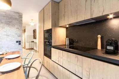 a kitchen with wooden cabinets and a table and chairs at Bright apartment ideal in Les Houches for 4 in Les Houches