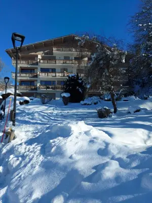a building in the snow with a pile of snow at Appartement Le Pacha - Proche Centre Ville in Megève