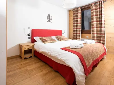 a bedroom with a large bed with a red headboard at Apartment Wohnung in Chamonix Centre-Ville by Interhome in Chamonix-Mont-Blanc