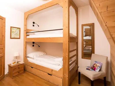 a bunk bed in a room with a chair and a mirror at Apartment Wohnung in Chamonix Centre-Ville by Interhome in Chamonix-Mont-Blanc
