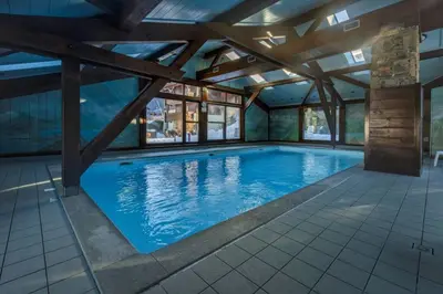 a large swimming pool with a wooden ceiling at Chavants Apart 3CH Famille Pied Piste Piscine Parking in Les Houches