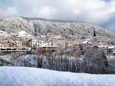 a town covered in snow in front of a mountain at Apartment Vent d'Est by Interhome in Mémontel