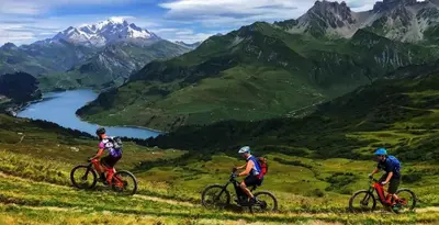 three people riding bikes on a hill with a view of mountains at Loft Apartment High Rimaye - Mont Blanc Views, Close to Brevent in Chamonix-Mont-Blanc