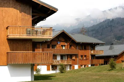 a building with a balcony on the side of it at Lagrange Vacances Les Fermes de Samoëns in Samoëns