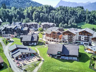 a green field with snow capped mountains in the background at Appartement 3 pièces pour 6 personnes avec parking à Morillon 1100 - FR-1-815-56 in Morillon