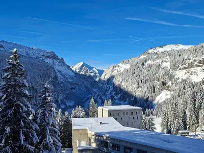 a snow covered mountain with a building and a tree at Appartement rénové près des pistes - Balcon, 5/6 pers. - FR-1-425-47 in Flaine