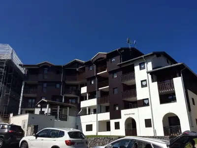 a large apartment building with cars parked in front of it at Appartement cosy 2 pièces pour 4 à Morillon 1100, proche pistes - FR-1-815-65 in Morillon