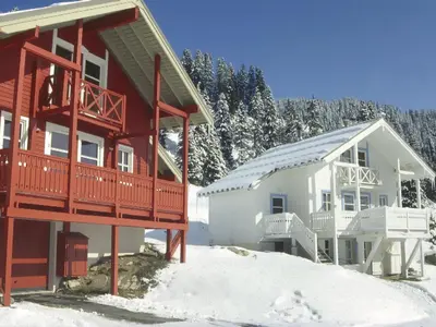 a home with a red and white house in the snow at Chalet spacieux 12 pers. à Flaine avec Sauna & Cheminée - FR-1-425-4 in Flaine