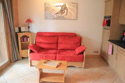 a living room with a red couch and a table at At Home in Les Carroz d'Araches