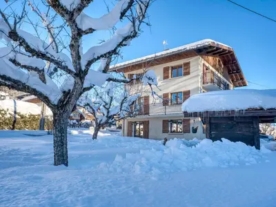 a house covered in snow next to a tree at Appartement cosy à Megève, 1 chambre, parking, wifi - FR-1-453-59 in Megève