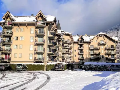 a swimming pool with lounge chairs next to a building at Apartment Le Grand Panorama 412 by Interhome in Saint-Gervais-les-Bains