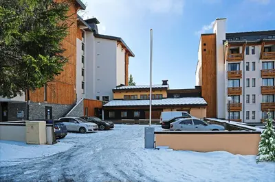 a parking lot with cars parked in the snow at Winter Vacances - Megève excellent apartment - AE 301 in Megève