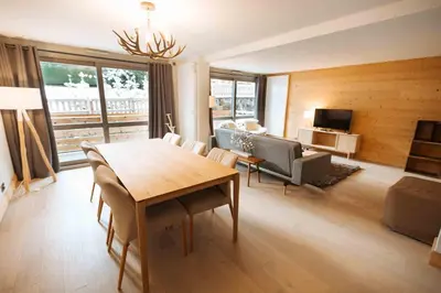 a living room with a dining room table and a couch at Megeve Appartment – Vacances d'hiver – АЕ102 in Megève