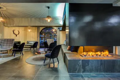 a lobby with a fireplace and chairs at The Drus Luxury Apartment with Spa and Indoor Pool in Chamonix-Mont-Blanc