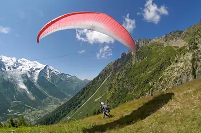 a person flying a parachute on a mountain at Apartment Grepon 3A - A Central Chamonix Haven in Chamonix-Mont-Blanc