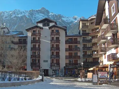 a large apartment building with snowy mountains in the background at Apartment La Forclaz-2 by Interhome in Chamonix-Mont-Blanc