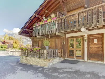 a wooden house with a balcony with flowers on it at Studio Les G'rets-10 by Interhome in Saint-Gervais-les-Bains
