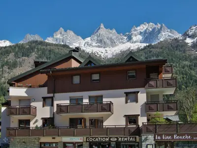 a large building with mountains in the background at Apartment L'Espace Montagne-15 by Interhome in Chamonix-Mont-Blanc