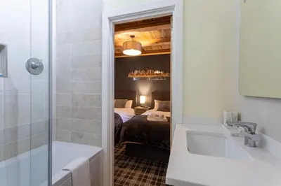 a bathroom with a bath tub and a bedroom at Chalet des Amis- Chamonix All Year in Chamonix-Mont-Blanc