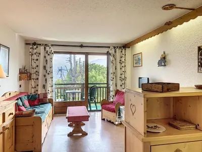 a room with a bed and a window with a balcony at Studio agréable au centre de Combloux avec parking - FR-1-560-35 in Combloux