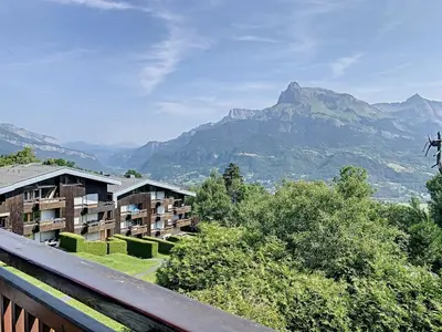 a view of a hotel with mountains in the background at Studio agréable au centre de Combloux avec parking - FR-1-560-35 in Combloux