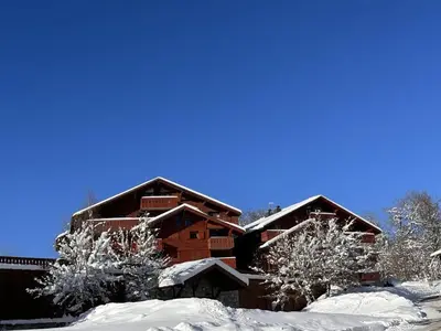 a log cabin in the snow with two trees at Appartement 3 Pièces 6 Pers avec Balcon aux Carroz - FR-1-572-53 in Les Carroz d'Araches
