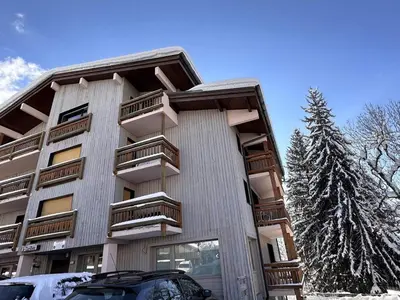 a building with balconies and a car parked in front of it at Studio rénové cosy, 4 pers, au pied des pistes, balcon ouest, proche commerces, parking inclus - FR-1-572-66 in Les Carroz d'Araches