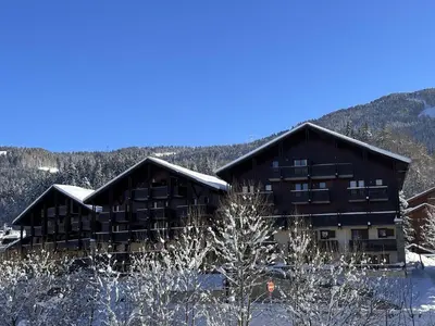 a large building with snow on the ground at Appartement Central 6 Pers, Parking, Ascenseur, Proche Pistes et Commerces - FR-1-572-22 in Les Carroz d'Araches
