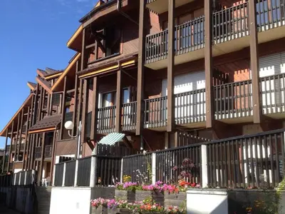 a large building with flowers in front of it at Studio chaleureux 4 pers, centre village, proche pistes et commerces, balcon sud-ouest - FR-1-572-105 in Les Carroz d'Araches