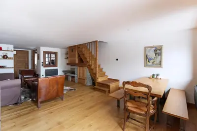 a living room with a staircase and a dining room table at House Berenice - Chamonix les Praz in Chamonix-Mont-Blanc