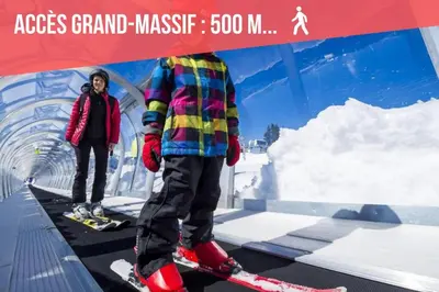 two people standing on skis under a sign at GREEN APPLE CARROZ Duplex WIFI Garage Balcon-Sud Vue Montagne in Les Carroz d'Araches