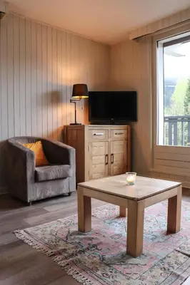 a living room with a tv and a coffee table at Appartement Lyret centre Chamonix, Vue d'exception in Chamonix-Mont-Blanc