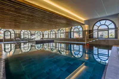 a swimming pool in a building with windows at La Cordee 124 Apartment - Chamonix All Year in Chamonix-Mont-Blanc