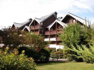 a large apartment building with trees in front of it at Appartement 5 pers. avec balcon privé et parking à Samoëns - FR-1-629-20 in Samoëns