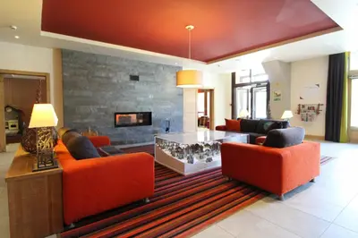a living room with orange chairs and a fireplace at Large one-bedroom apartment, wheelchair adapted, Les Terrasses d'Eos in Flaine