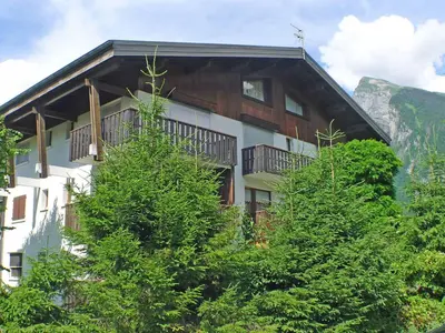a building with trees in front of a mountain at Duplex 4 pièces avec balcon et Wifi à Samoëns pour 8 pers - FR-1-629-3 in Samoëns