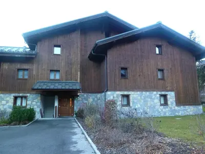 a large brick building with a door and a driveway at Appartement duplex spacieux avec piscine et WiFi à Samoëns - FR-1-624-9 in Samoëns